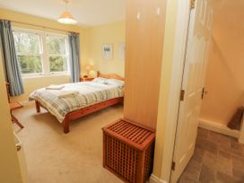 A bedroom with a bed, bedside lamp and wardrobe at Flat 17 in Keswick