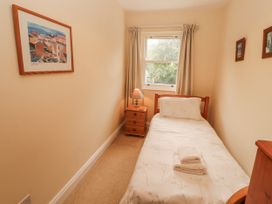 A bedroom with a single bed and a lamp on a nightstand at Flat 17 in Keswick