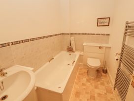 A bathroom with a bathtub, toilet, and washbasin at Flat 17 Keswick