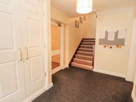 A hallway with a staircase and a wardrobe at Flat 17 in Keswick