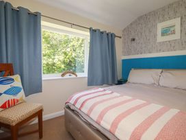 A bedroom with a bed and chair at 64 St Columb Nr Newquay