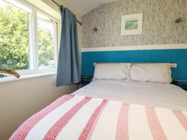 A bedroom with a bed and windows at 64 St Columb Nr Newquay
