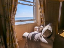 A sitting room with a chair and window at 123 On The Sea – Victoria’s Place Weymouth