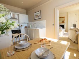 A kitchen with dining table and chairs at 123 On The Sea – Victoria’s Place Weymouth