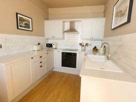 A kitchen with cabinets and appliances at 123 On The Sea – Victoria’s Place, Weymouth