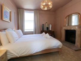 A bedroom with a bed and a fireplace at 123 On The Sea – Victoria’s Place in Weymouth