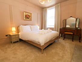 A bedroom with a bed and a dressing table at 123 On The Sea – Victoria’s Place, Weymouth