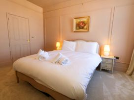 A bedroom with a bed and bedside table at 123 On The Sea – Victoria’s Place in Weymouth