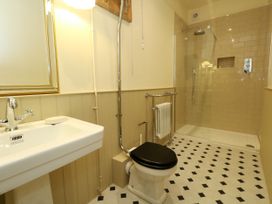 A bathroom with a sink, toilet, shower, and radiator at 123 On The Sea – Victoria’s Place Weymouth