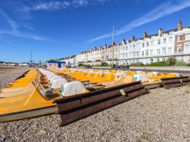 Yellow paddle boats lined on the beach at 123 On The Sea – Victoria’s Place in Weymouth
