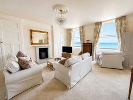 A living room with a sofa, chair, coffee table and television at 123 On The Sea – Victoria’s Place in Weymouth