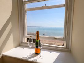A window with champagne and glasses overlooking the sea at 123 On The Sea – The Eaves in Weymouth