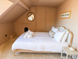 A bedroom with a bed and wardrobe at 123 On The Sea – The Eaves in Weymouth