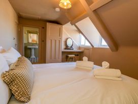 A bedroom with a bed and dresser at 123 On The Sea – The Eaves Weymouth