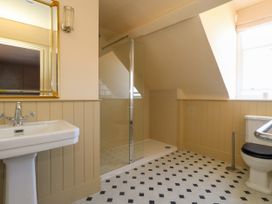 A bathroom with a sink, shower, mirror, and toilet at 123 On The Sea – The Eaves in Weymouth