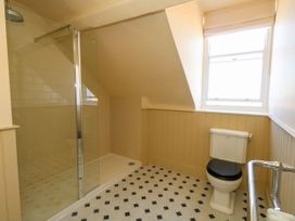 A bathroom with a shower and toilet at 123 On The Sea – The Eaves, Weymouth