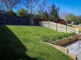 A garden with grass and a flower bed at The Nightingale in Weymouth