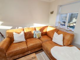 A living room with a brown sofa and cushions at Nene's Nest in Alnwick