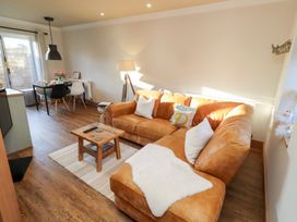 A living room with a sofa and dining table at Nene's Nest in Alnwick