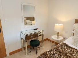 A bedroom with a dressing table and a lamp at Nene's Nest in Alnwick