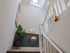 A staircase with a plant and mirror at Jasper in Lyme Regis