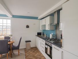 A kitchen with a stove and dining table at Jasper in Lyme Regis