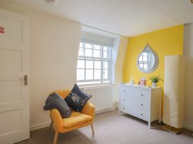 A bedroom with an armchair and dresser at Jasper in Lyme Regis