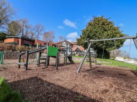 A playground with swings and equipment at Woodlands Retreat Llanfwrog near Ruthin