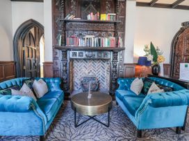 A living room with a blue sofa and coffee table at Woodlands Retreat in Llanfwrog near Ruthin