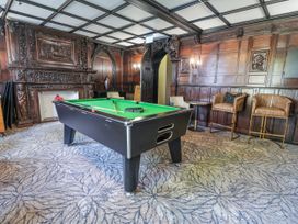 A game room with a pool table and bar stools at Woodlands Retreat Llanfwrog near Ruthin