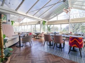 A dining room with tables and chairs at Woodlands Retreat in Llanfwrog near Ruthin
