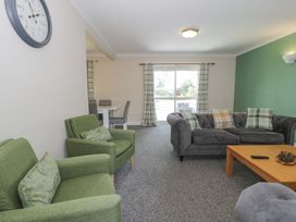 A living room with green and gray furniture at Woodlands Retreat in Llanfwrog near Ruthin