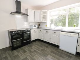 A kitchen with an oven, microwave, and dishwasher at Woodlands Retreat in Llanfwrog near Ruthin