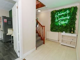 A hallway with a staircase and a neon sign at Woodlands Retreat Llanfwrog near Ruthin
