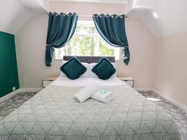 A bedroom with a bed and cushions at Woodlands Retreat in Llanfwrog near Ruthin