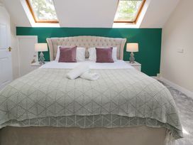 A bedroom with a bed and bedside lamps at Woodlands Retreat Llanfwrog near Ruthin