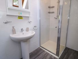 A bathroom with a sink and shower at Woodlands Retreat in Llanfwrog near Ruthin