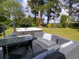 An outdoor seating area with a hot tub at Woodlands Retreat in Llanfwrog near Ruthin
