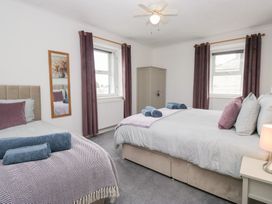 A bedroom with two beds and a wardrobe at 3 Nixon Terrace, Broughton Moor near Maryport