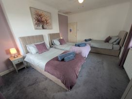 A bedroom with three beds and a nightstand at 3 Nixon Terrace Broughton Moor near Maryport