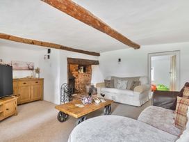 A living room with a sofa and a TV at 2 Pigsfoot Cottages Ash Thomas near Halberton, Devon