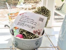 A dog bowl with toys and treats along with a welcome note at 2 Pigsfoot Cottages Ash Thomas near Halberton, Devon