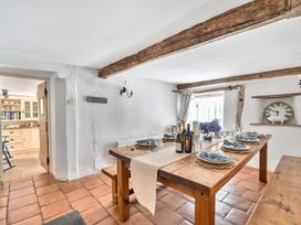 A dining room with a wooden table set for a meal at 2 Pigsfoot Cottages Ash Thomas near Halberton, Devon