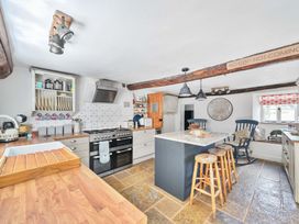A kitchen with a stove and island at 2 Pigsfoot Cottages Ash Thomas near Halberton, Devon