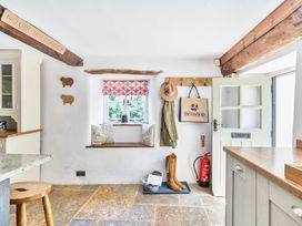 A kitchen with a seat by the window at 2 Pigsfoot Cottages Ash Thomas near Halberton, Devon