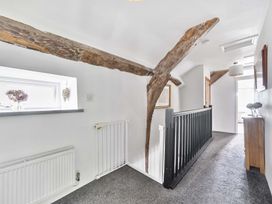 A hallway with wooden beams and a window at 2 Pigsfoot Cottages Ash Thomas near Halberton, Devon