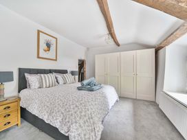 A bedroom with a bed and wardrobe at 2 Pigsfoot Cottages Ash Thomas near Halberton, Devon