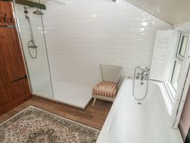 A bathroom with a shower, bathtub, and chair at Pentira in Kuggar
