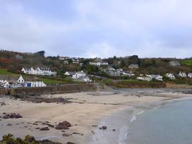 A beach with water and houses in the background at The Mariners in Coverack