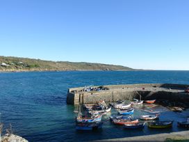 A harbor with boats docked and hills in the background at The Mariners in Coverack